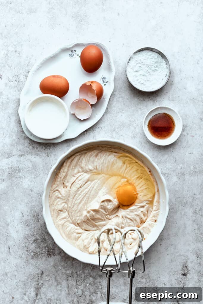 Eggs are mixed into a bowl of turtle cheesecake batter.