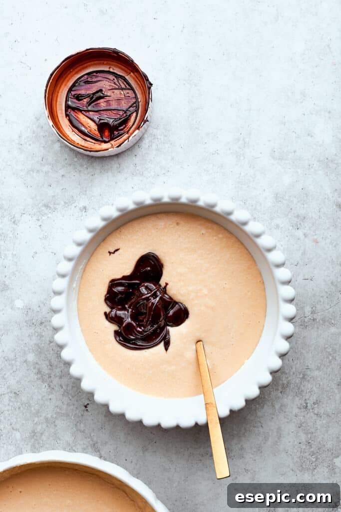 Melted chocolate is stirred into a bowl of cheesecake filling.