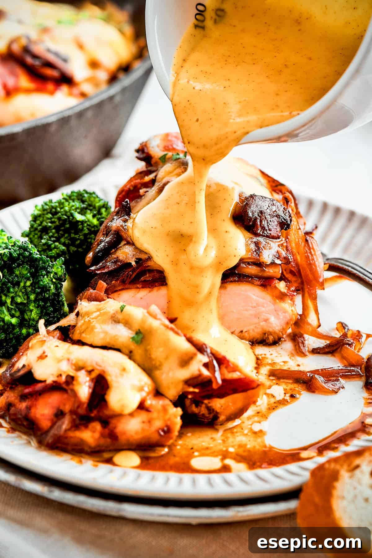 A thick stream of vivid yellow honey mustard sauce is added to a plate of Alice Springs chicken.