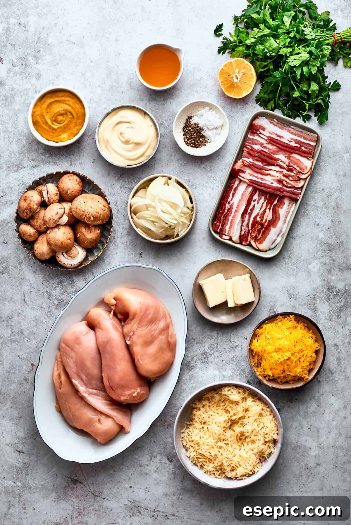 The ingredients to make Alice Springs chicken are shown portioned out: chicken, mushrooms, honey, mayo, mustard, garlic, onion, butter, bacon, salt and pepper, cheddar and Jack cheeses.