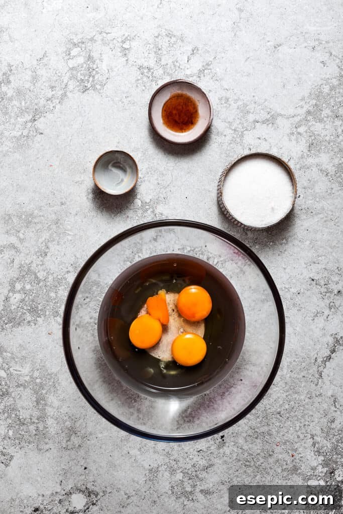 The egg mixture for the filling before heating. Large eggs, granulated sugar, and water are combined in a bowl, ready to be beaten for the French Silk Pie filling.