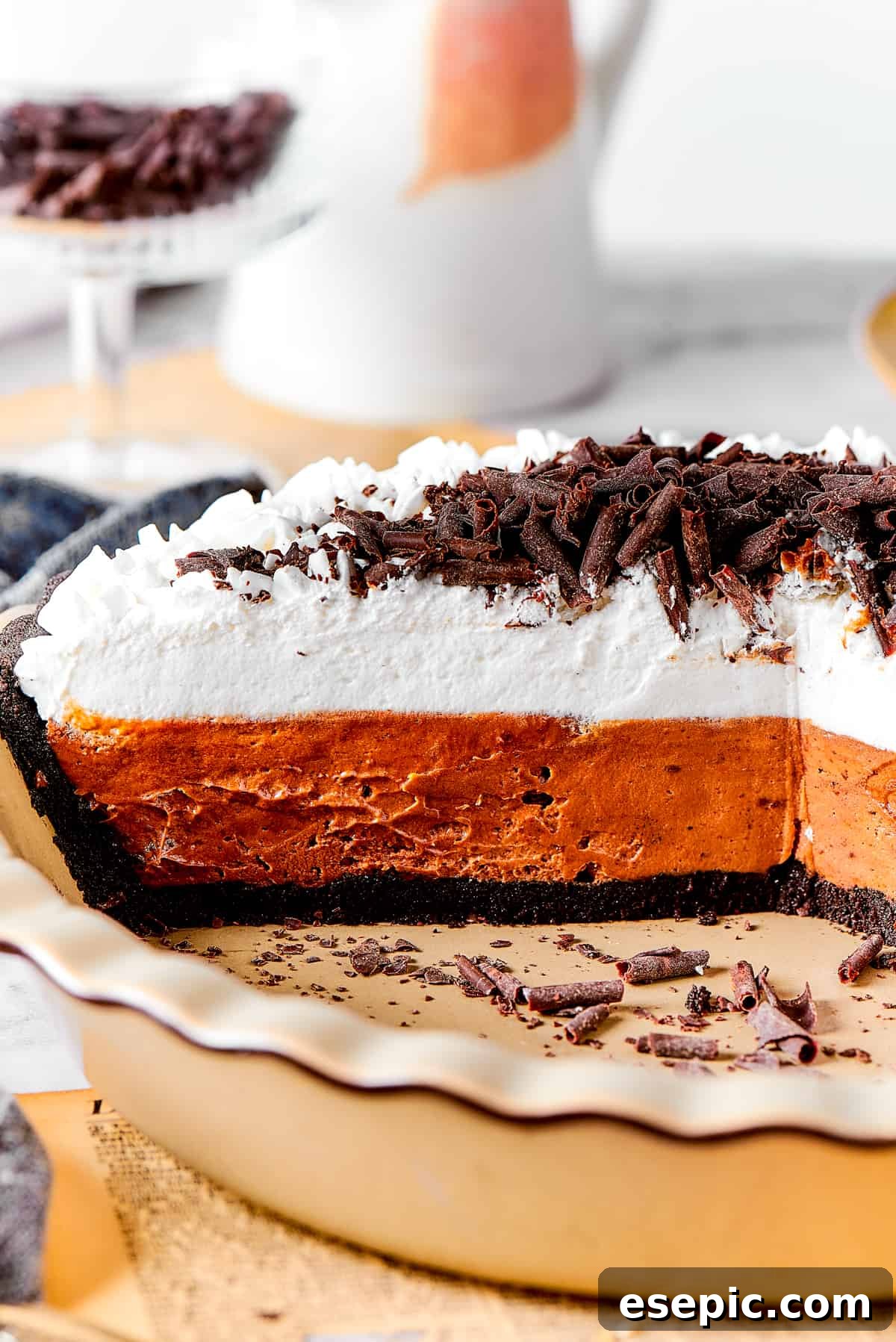 The classic beauty of a freshly made French Silk Pie. Whole French silk pie, perfectly chilled, featuring its dark chocolate filling topped with decorative swirls of vanilla whipped cream.