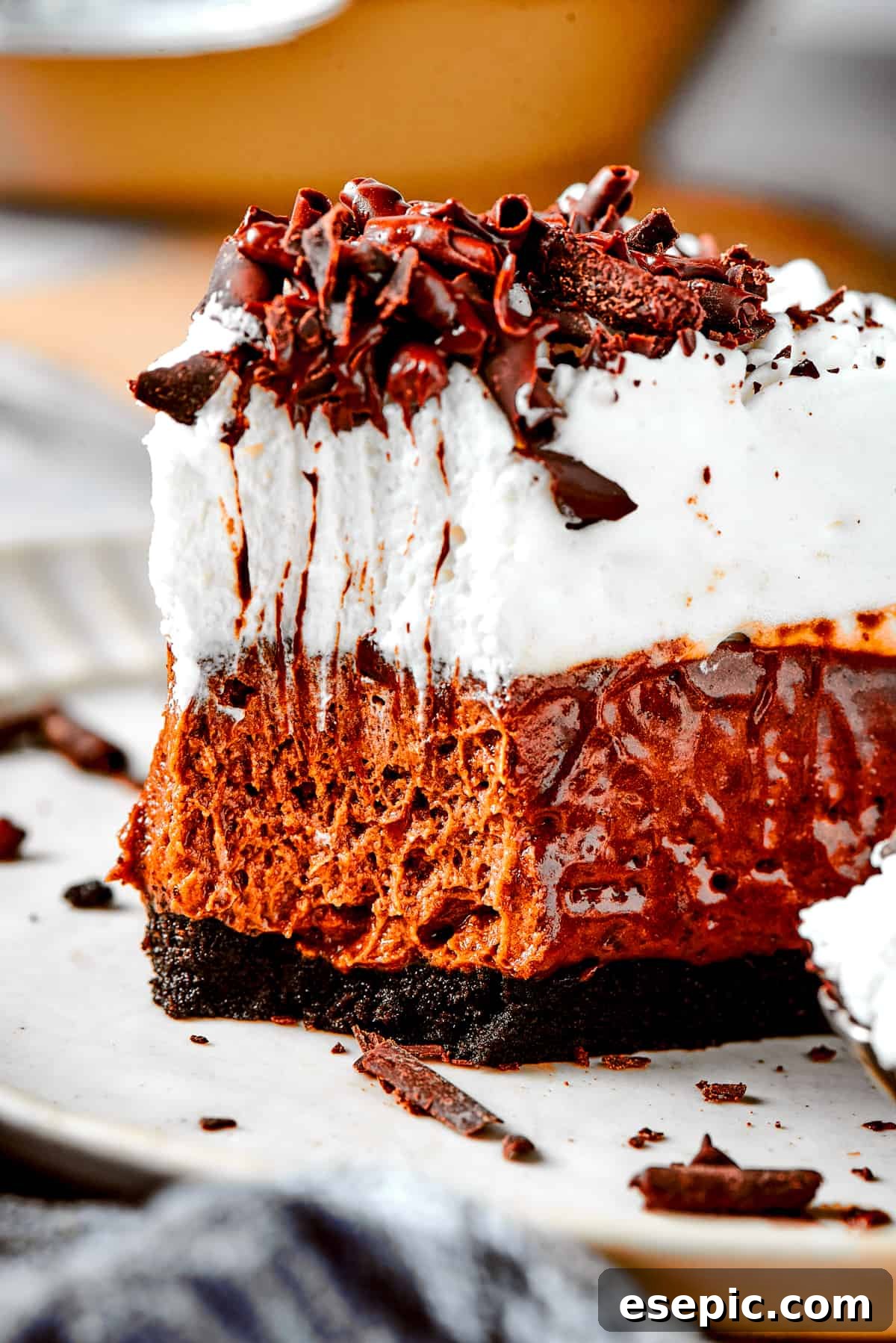 A delicious bite of French Silk Pie. A perfectly portioned slice of French silk pie on a white dessert plate, with a fork holding a tantalizing bite of pie.