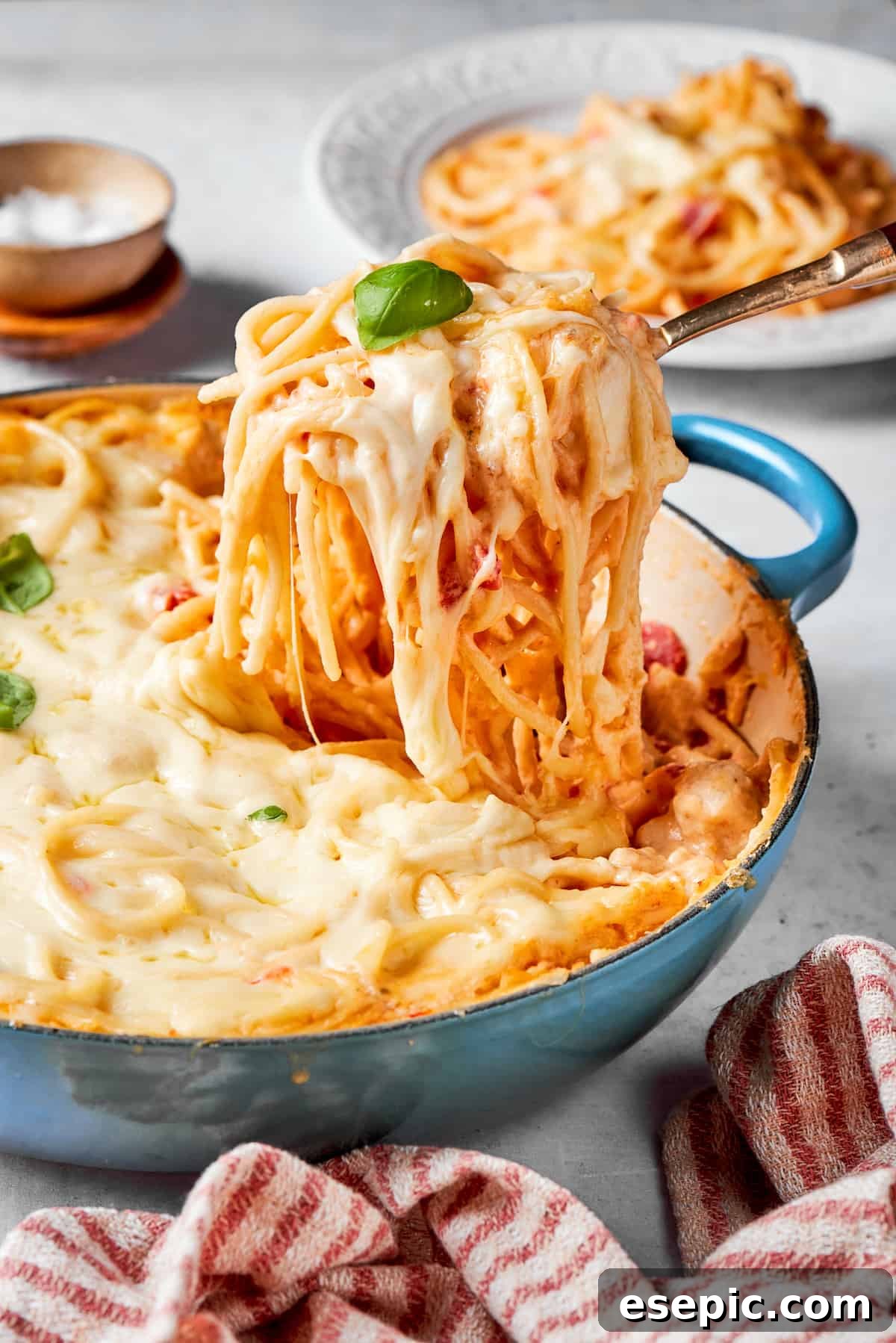 Cheesy Chicken Spaghetti: A Rich, Creamy, and Easy Pasta Bake A serving utensil lifts out a portion of cheesy chicken spaghetti, showcasing the creamy pasta and melted cheese.