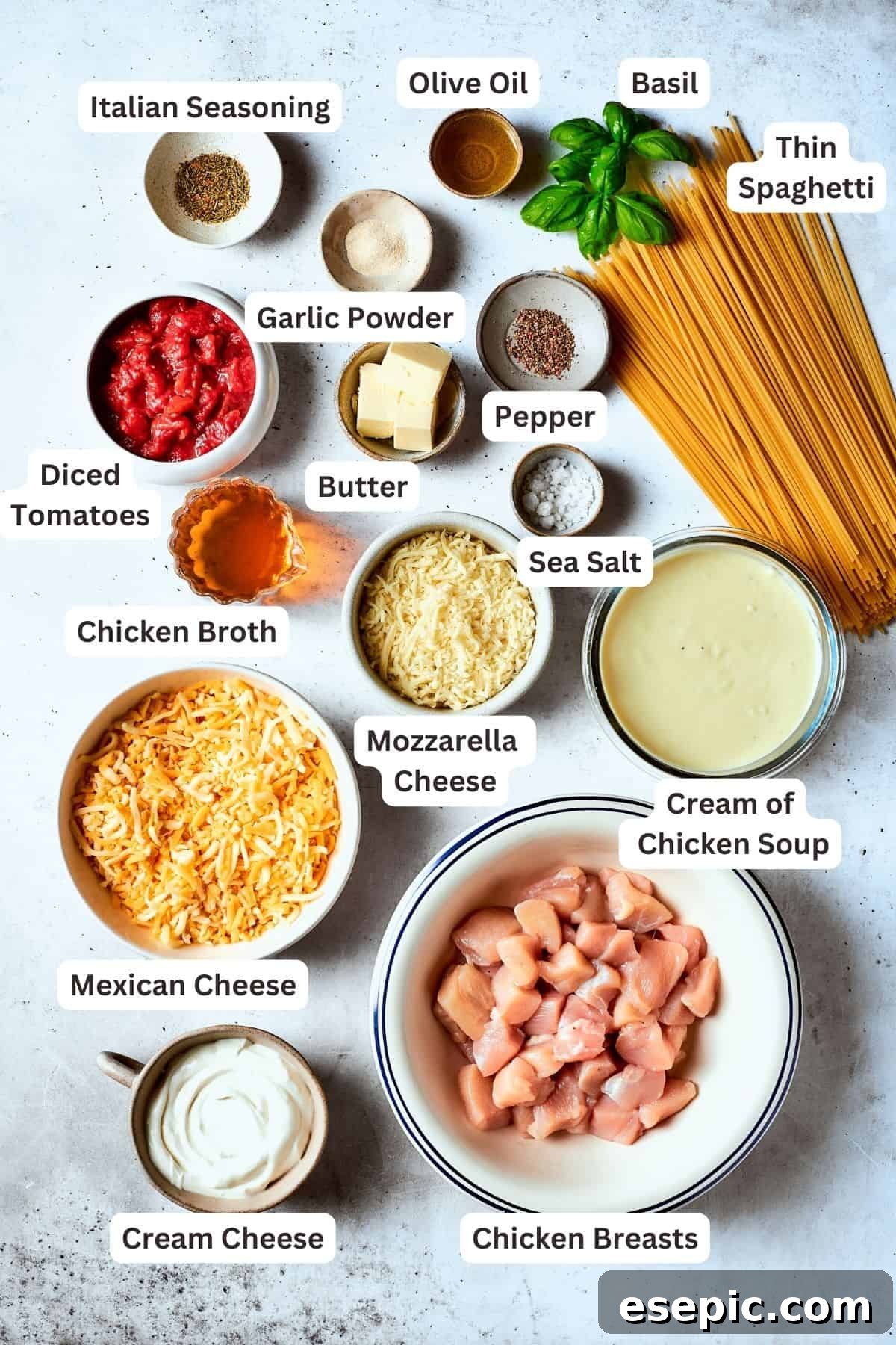 Fresh and pantry staples for Cheesy Chicken Spaghetti Ingredients needed for cheesy chicken spaghetti are shown portioned out: spaghetti, chicken, tomatoes, mozzarella cheese, Mexican cheese blend, cream of chicken soup, salt and pepper, broth, butter, garlic and onion powders, cream cheese.