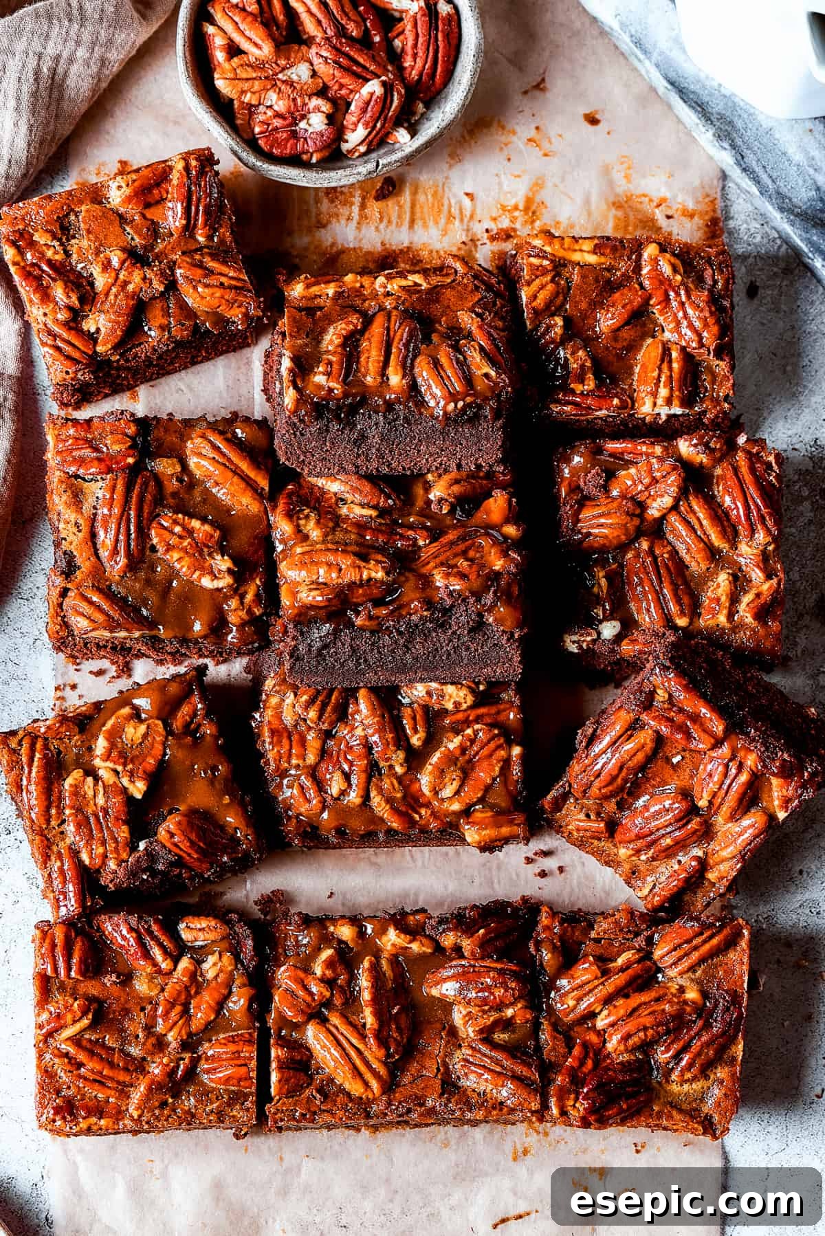An array of delicious Pecan Pie Brownies. Pecan brownie squares arranged on a light surface.
