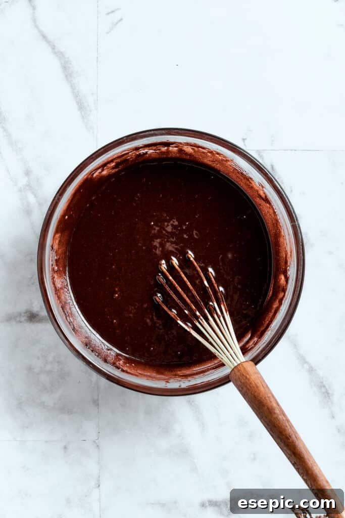 Whisking brownie batter to smooth perfection. A whisk blends a bowl of brownie batter.