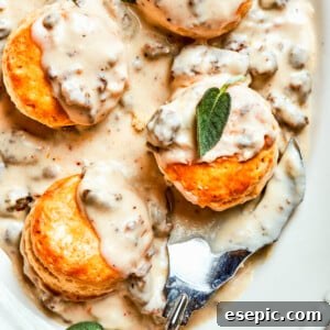 Sausage and gravy biscuits served on an oval white serving dish.