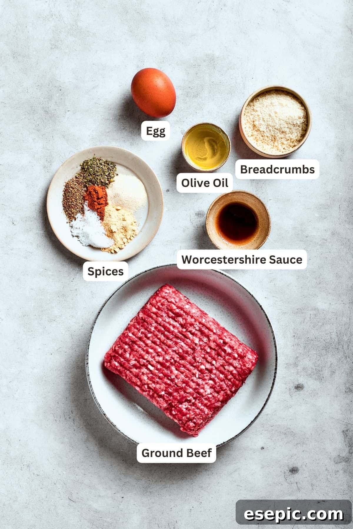 Ingredients for chopped steak are shown: ground beef, egg, seasonings, salt and pepper, olive oil, breadcrumbs, all neatly arranged.