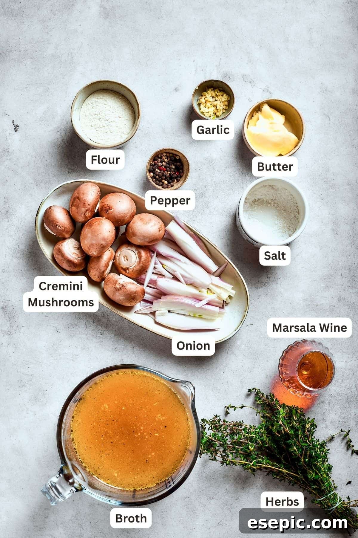Ingredients for mushroom gravy are shown: sliced mushrooms, flour, salt, Marsala wine, butter, minced garlic, sliced onion, beef broth, pepper, all ready for use.