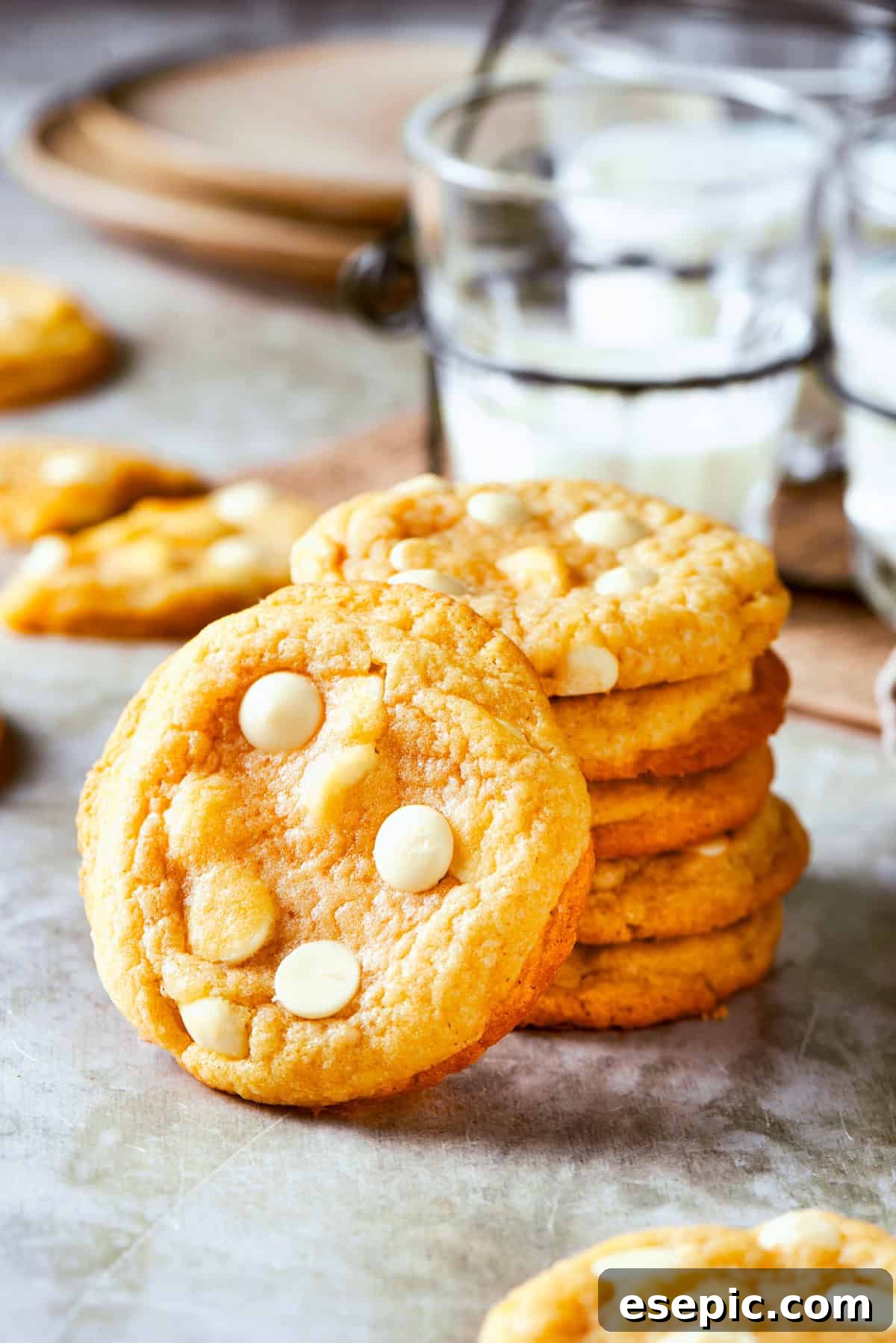 Stacked up chewy, buttery White Chocolate Chip Cookies, packed with creamy, sweet white chocolate chips for an unexpected twist. A beautiful stack of five perfectly baked chewy white chocolate chip cookies, garnished with a few loose white chocolate chips, creating an inviting display.