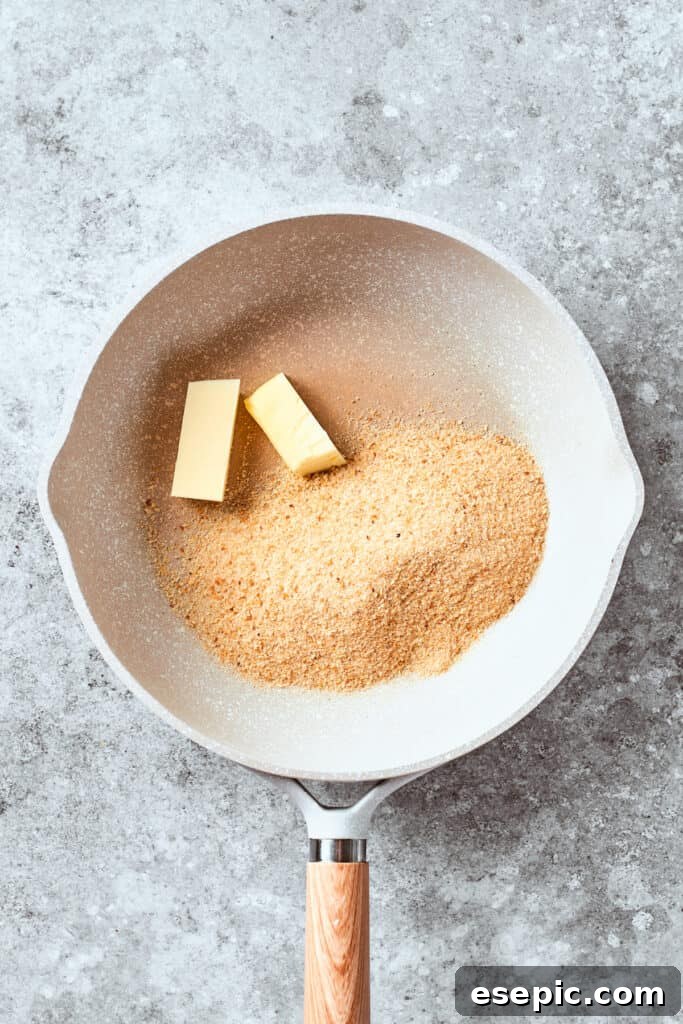 Melted butter in a pan with Panko breadcrumbs added, preparing the crunchy topping.