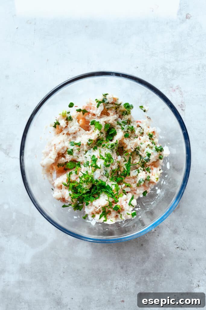 Fresh parsley is being added to the shrimp mixture, enhancing its flavor and visual appeal.