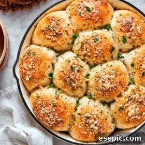 A skillet of baked pizza bites next to a bowl of sauce.