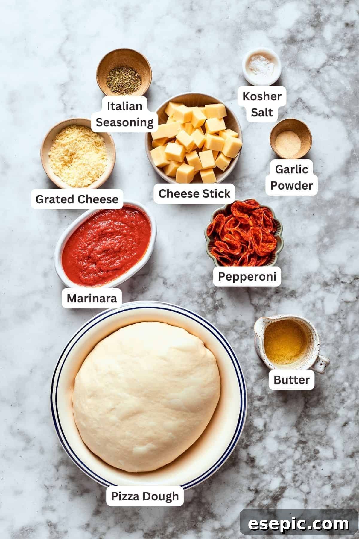 Ingredients for pizza burgers are labelled and portioned out: pizza dough, grated cheese, Italian seasoning, marinara sauce, pepperoni, butter, garlic powder, cheese stick, salt.