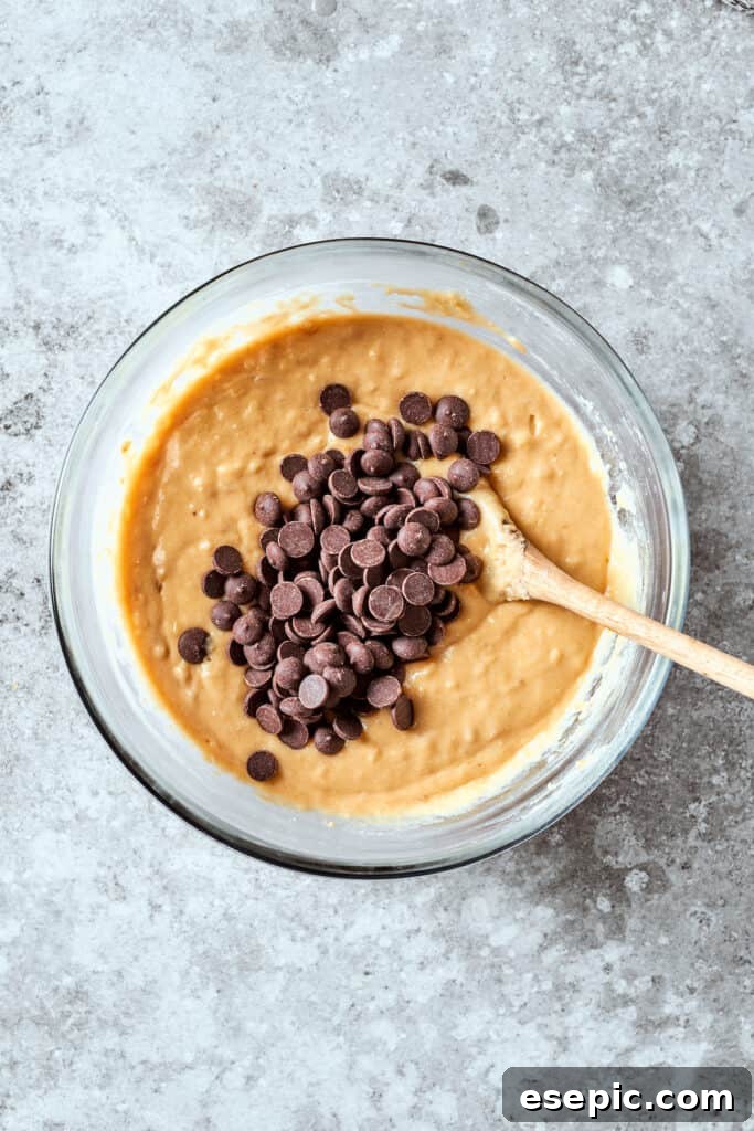 Chocolate chips are generously folded into the banana bread batter, promising delightful pockets of sweetness in every bite.