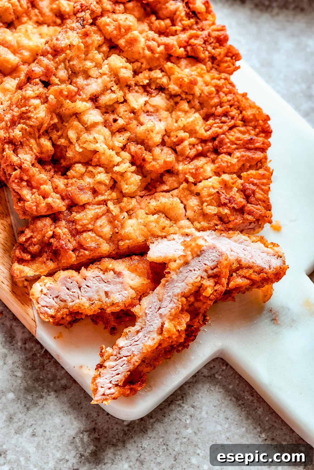 Golden Fried Country Steak 14 Breaded chicken fried steak on a cutting board.