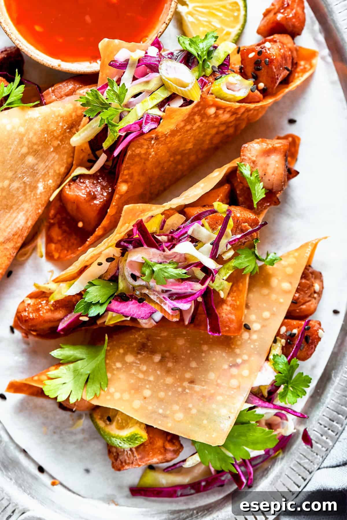 Overhead image of beautifully assembled chicken wonton tacos, packed with cooked chicken and vibrant coleslaw, ready to be served.