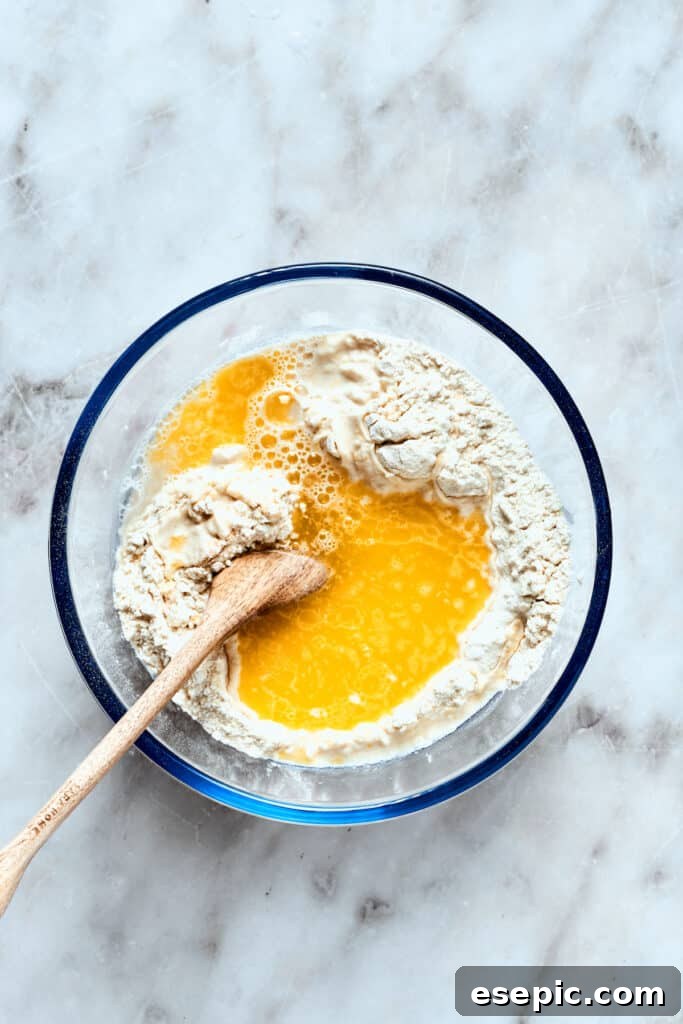Warm water and melted olive oil are carefully mixed into the dry deep dish pizza dough ingredients.