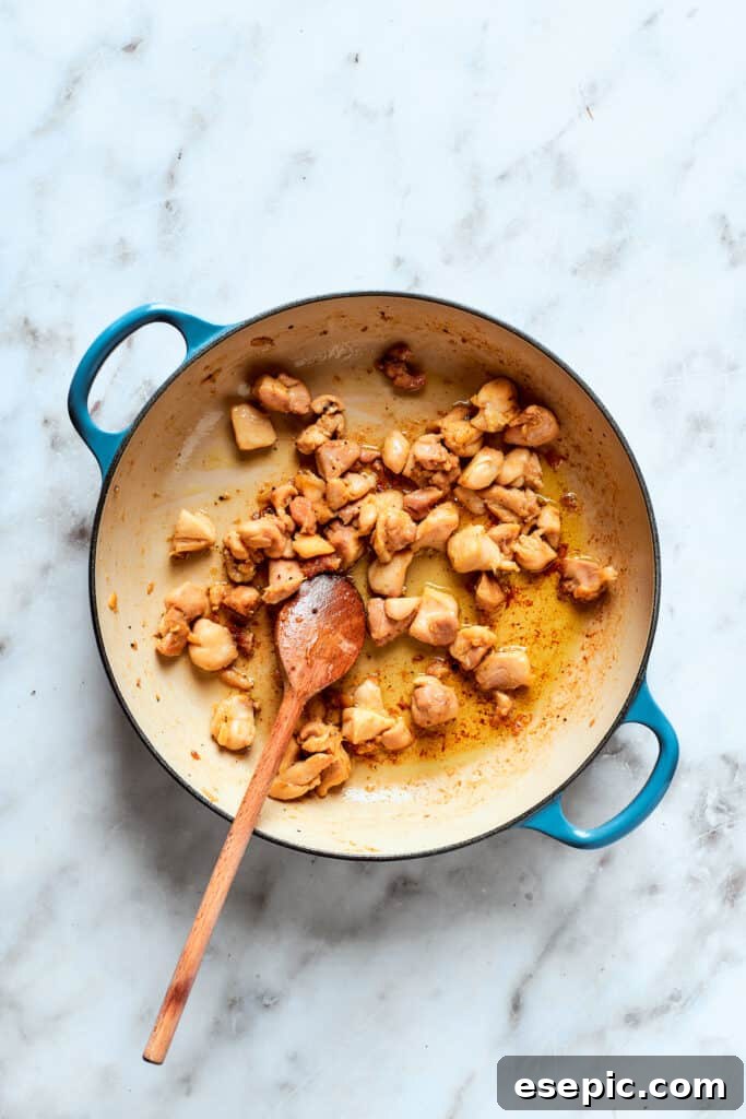 The chicken browns in the pot.