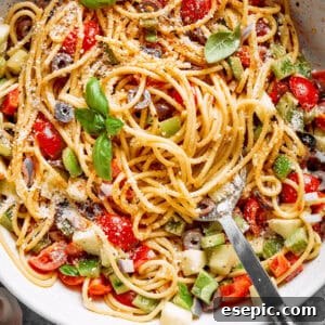 Fresh vegetables are shown in a bowl of spaghetti salad.