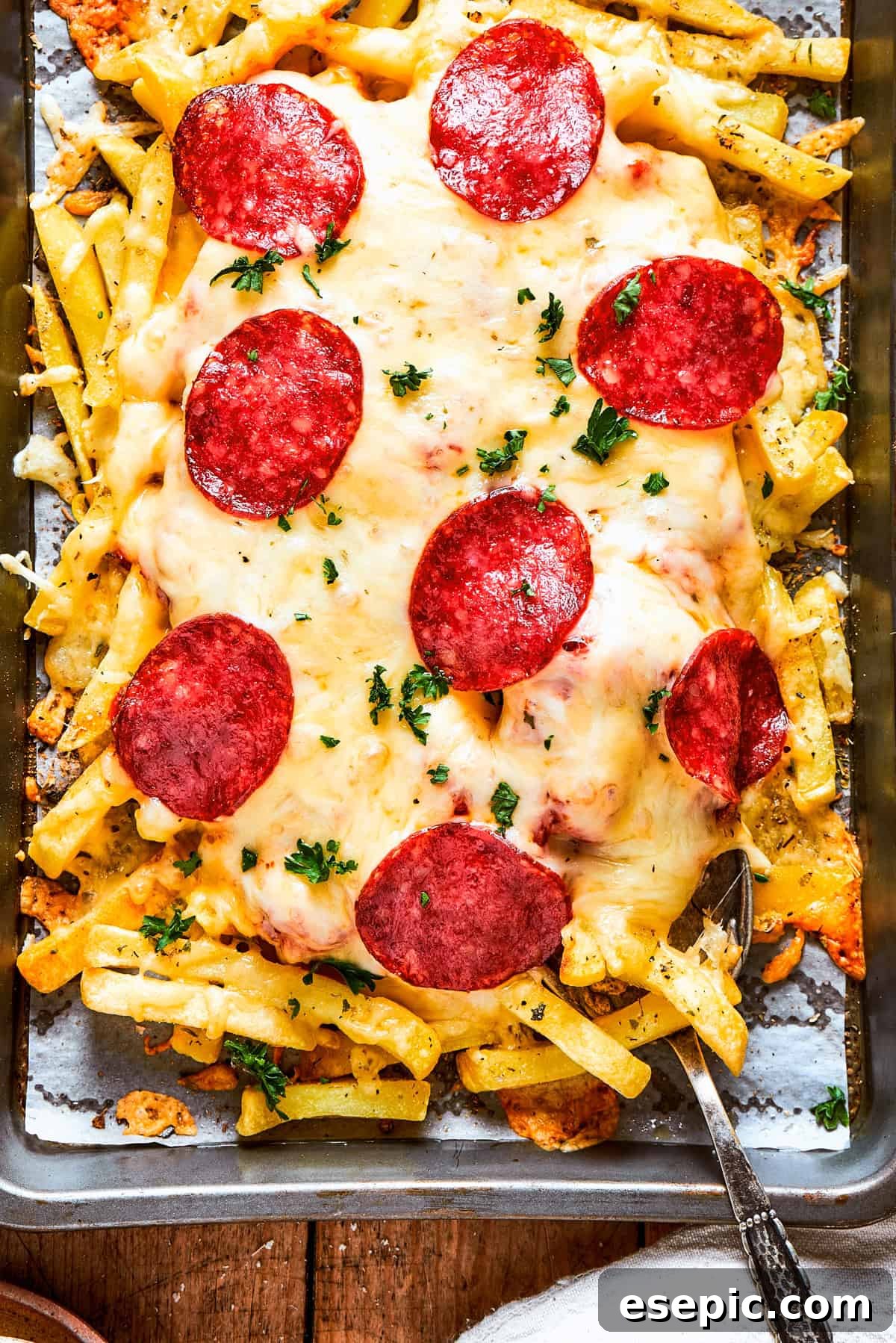 Pizza Fry Fusion 2 A tray of fries topped with melted cheese and slices of pepperoni.