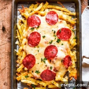 Pizza Fry Fusion 11 A baking tray with french fries topped with melted cheese and pepperoni.