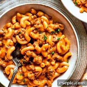 A bowl of macaroni tossed with beef sauce.