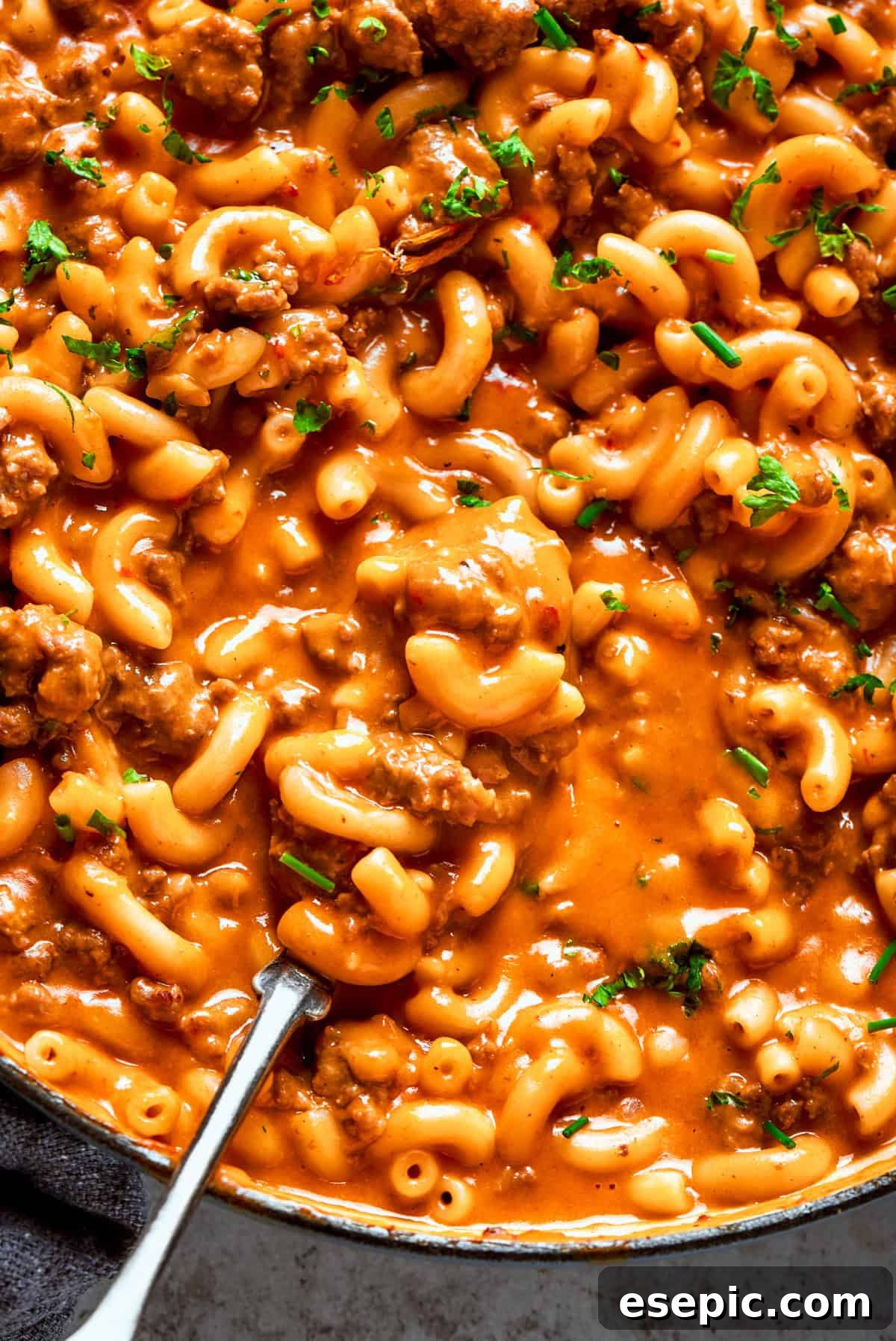Close-up photo of a generous portion of homemade hamburger helper, featuring perfectly cooked elbow macaroni blended into a rich, creamy ground beef sauce.