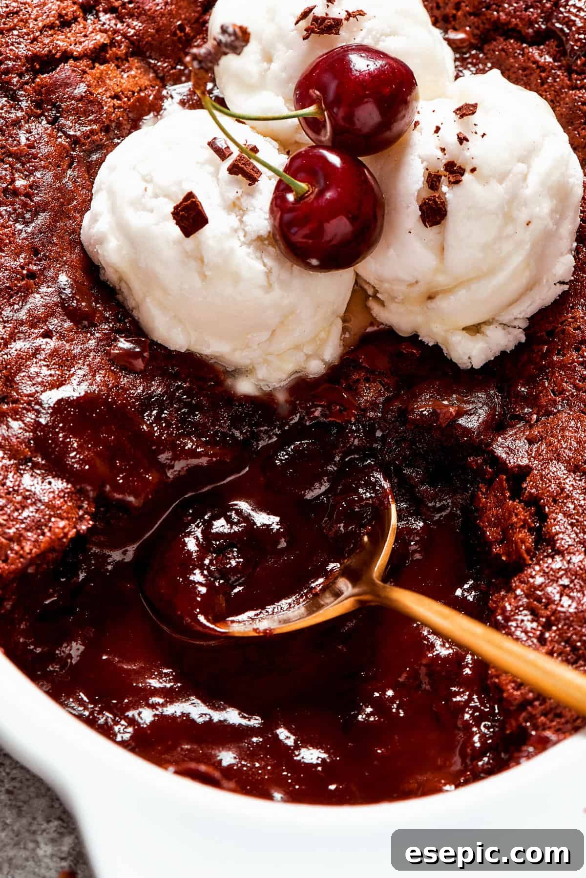 This moist and gooey Chocolate Pudding Cake is loaded with rich chocolate flavor in every bite. Best served warm! Close-up image of a spoon stirring through chocolate pudding cake.