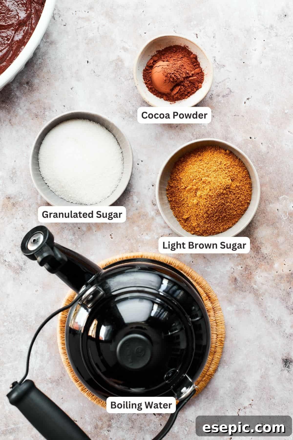 This moist and gooey Chocolate Pudding Cake is loaded with rich chocolate flavor in every bite. Best served warm! Chocolate pudding cake topping ingredients are labeled: boiling water, brown sugar, granulated sugar, cocoa powder.