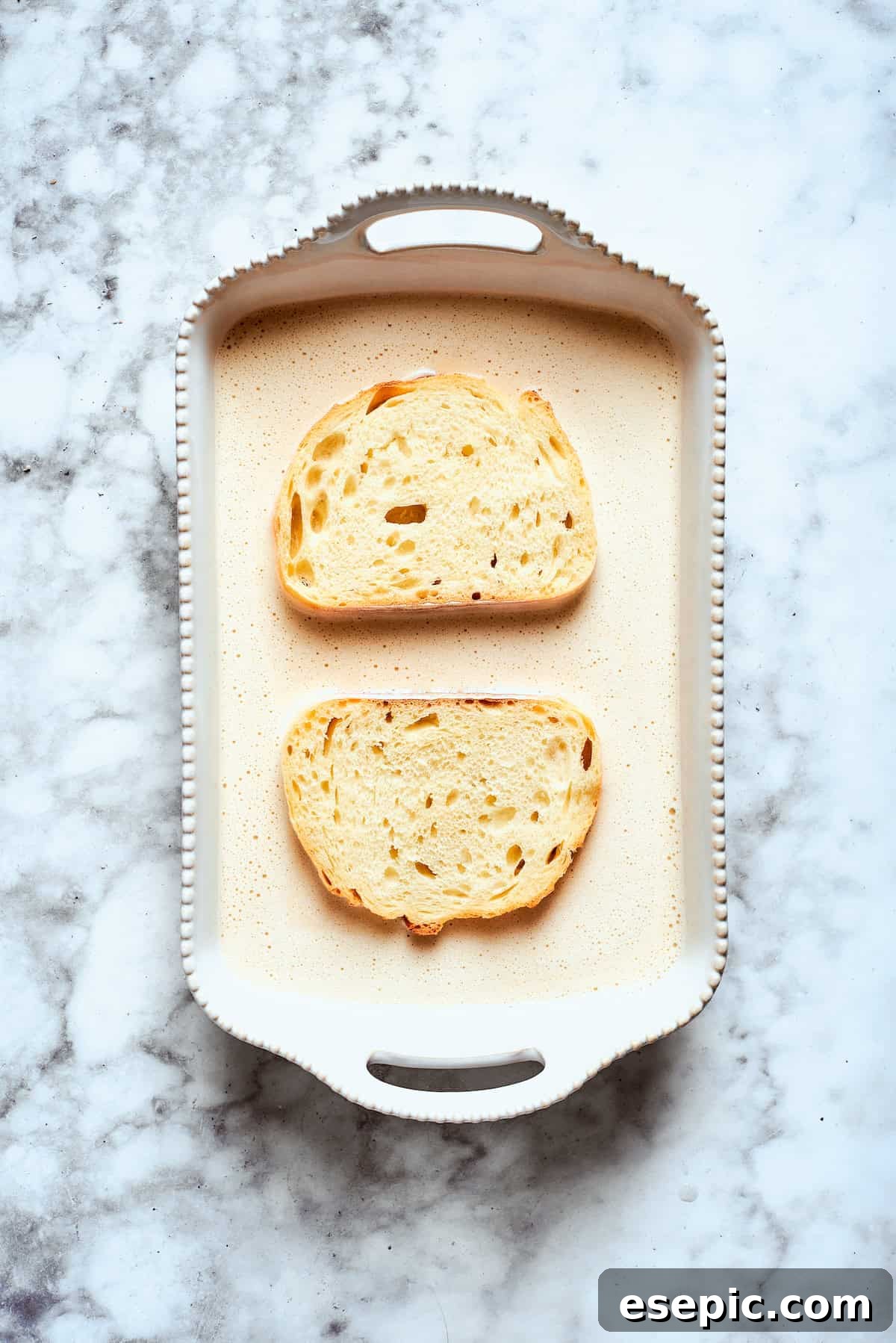 Two pieces of bread soak up the banana batter.