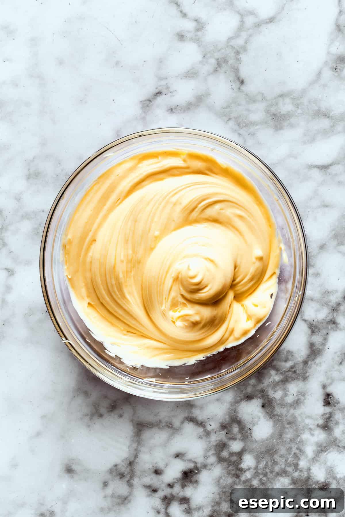 Instant vanilla pudding mix is whisked with milk in a bowl until thick.