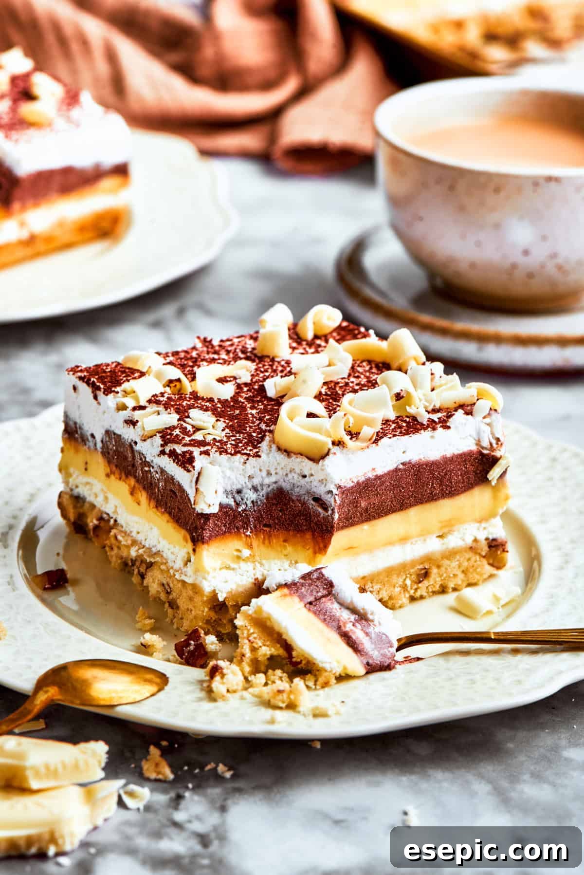 A perfectly portioned slice of Sex in a Pan, showing its distinct layers of chocolate, vanilla, and cream cheese on a pecan crust, ready to be enjoyed.