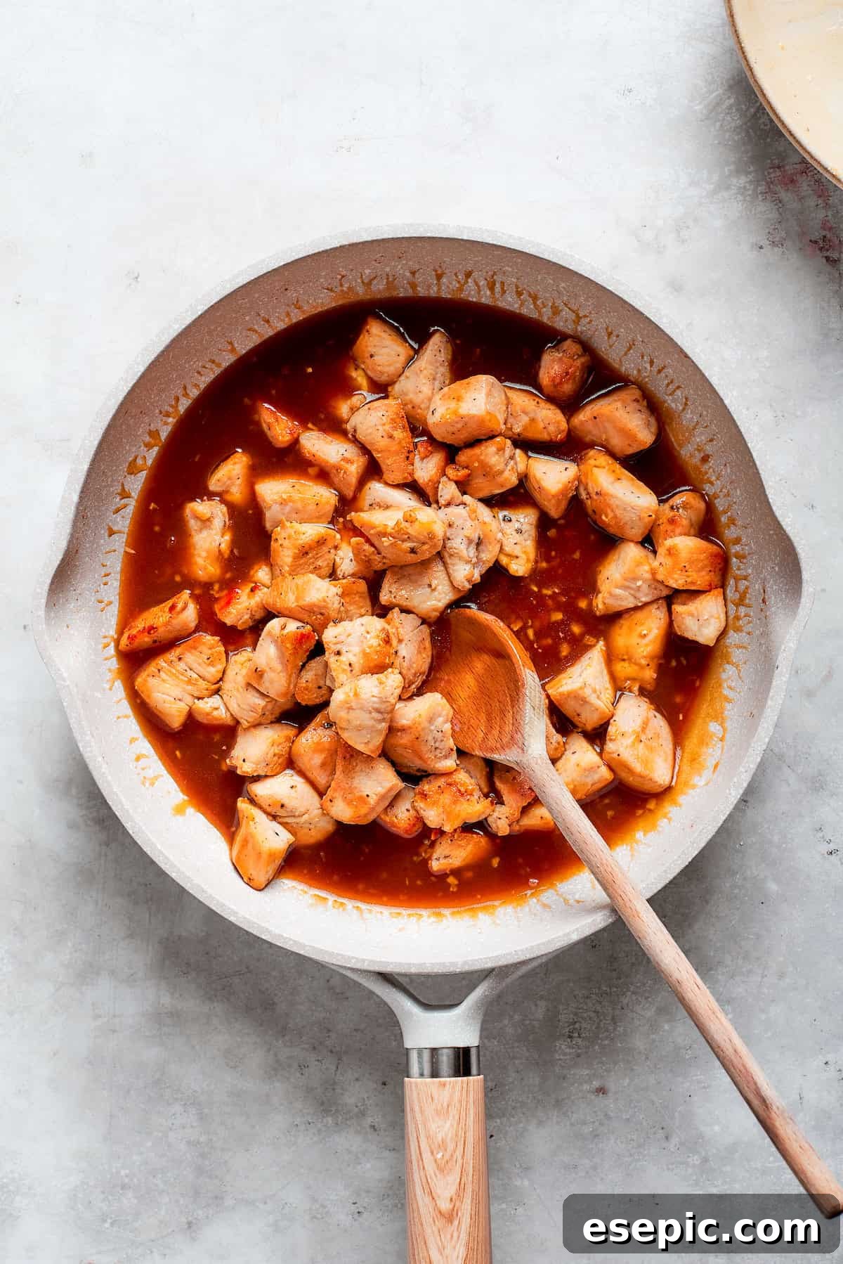 This Teriyaki Chicken Recipe folds tender bites of chicken into a thick, homemade teriyaki sauce for a savory and flavorful dish. The chicken is added back to the pan of sauce.