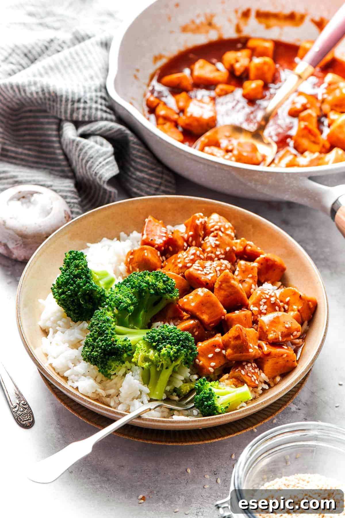 This Teriyaki Chicken Recipe folds tender bites of chicken into a thick, homemade teriyaki sauce for a savory and flavorful dish. Bowls of teriyaki chicken recipe are served with rice and broccoli.