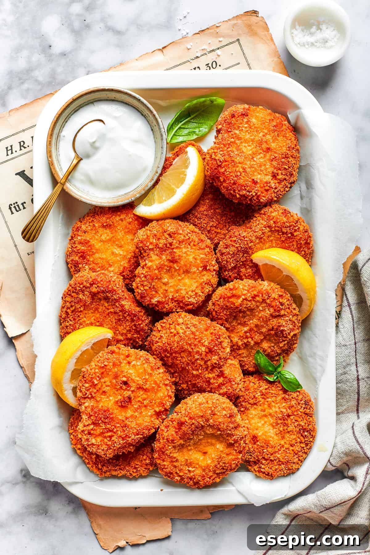 This easy homemade Chicken Nuggets Recipe features perfectly cooked homemade chicken nuggets that are crispy outside and juicy on the inside. A serving tray with homemade chicken nuggets and a dish of ranch dressing and lemon slices.