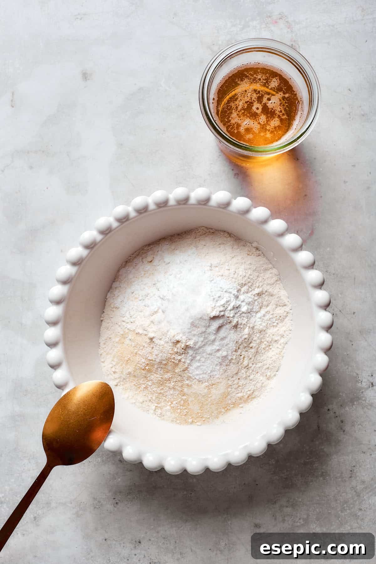 A bowl containing a dry mix of flour, salt, baking powder, and garlic powder, the foundation for the light and crispy beer batter.