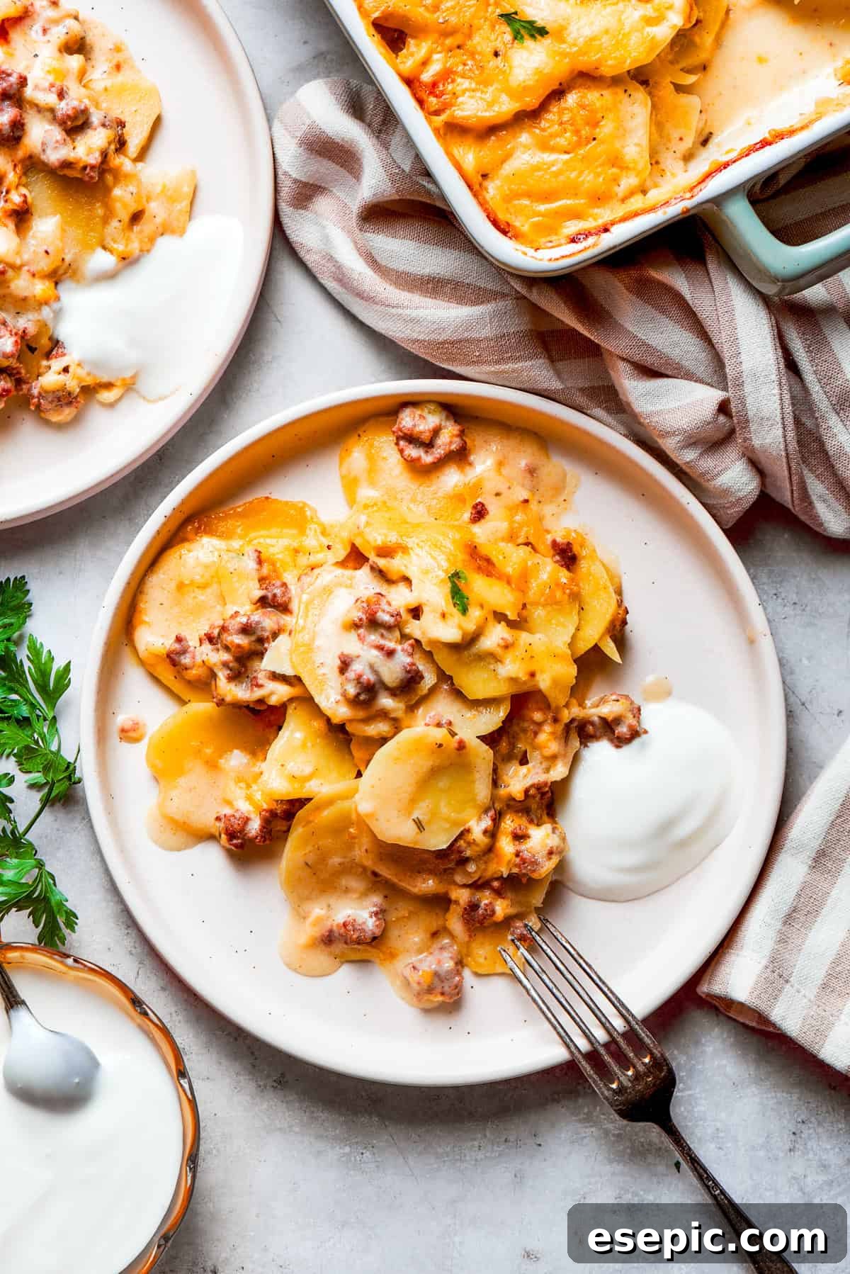 A portion of hamburger potato casserole served on dinner plates.