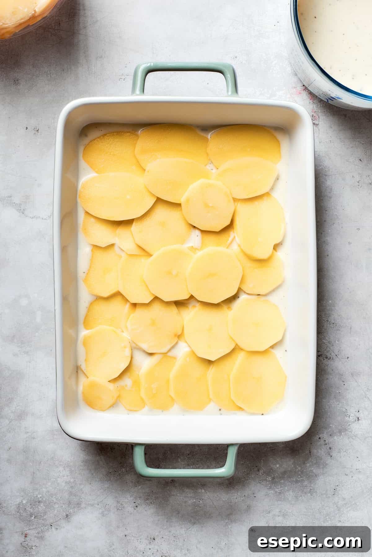 Sliced potatoes on the bottom of the pan.