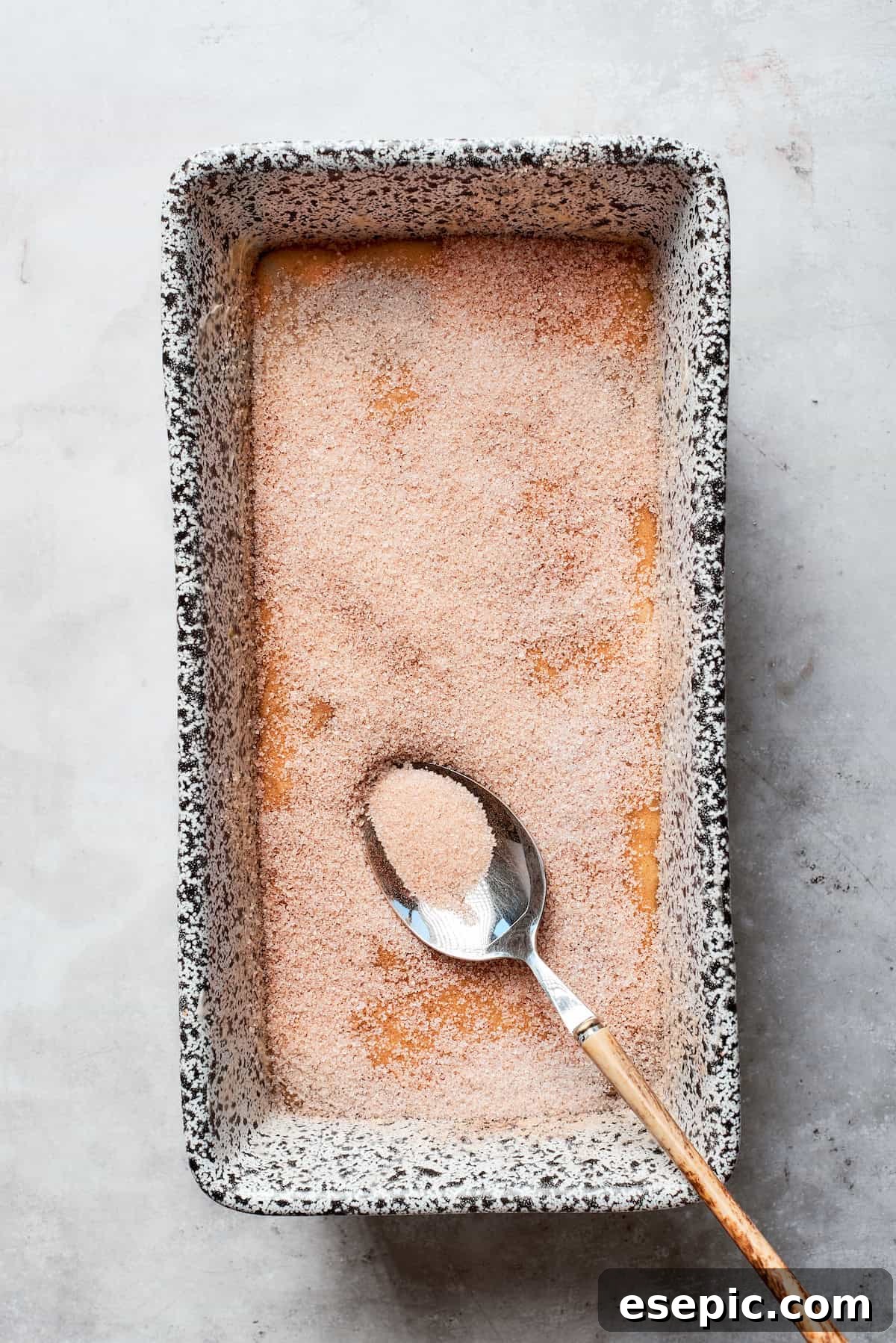 Sugar is added to the top of the batter in the pan.