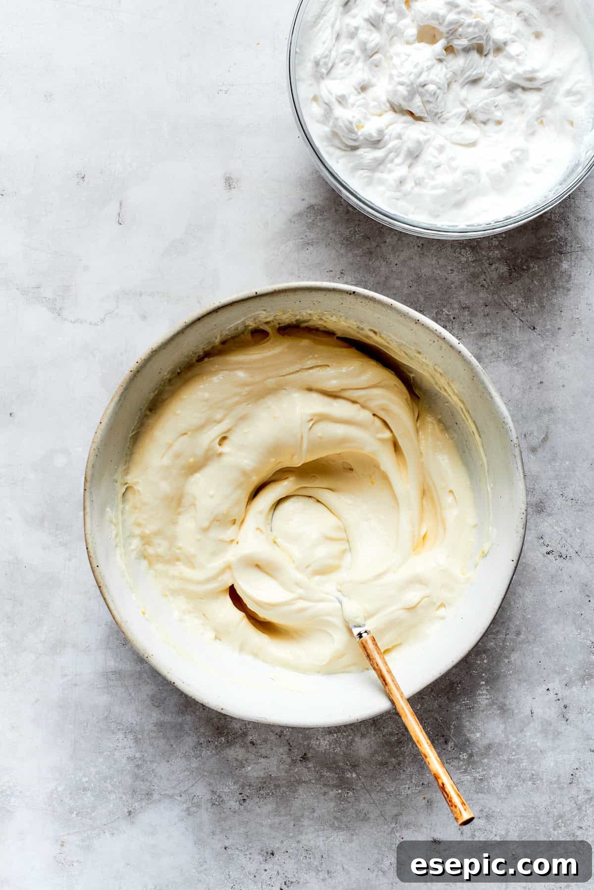 The mascarpone filling ingredients are being mixed thoroughly in a large bowl.