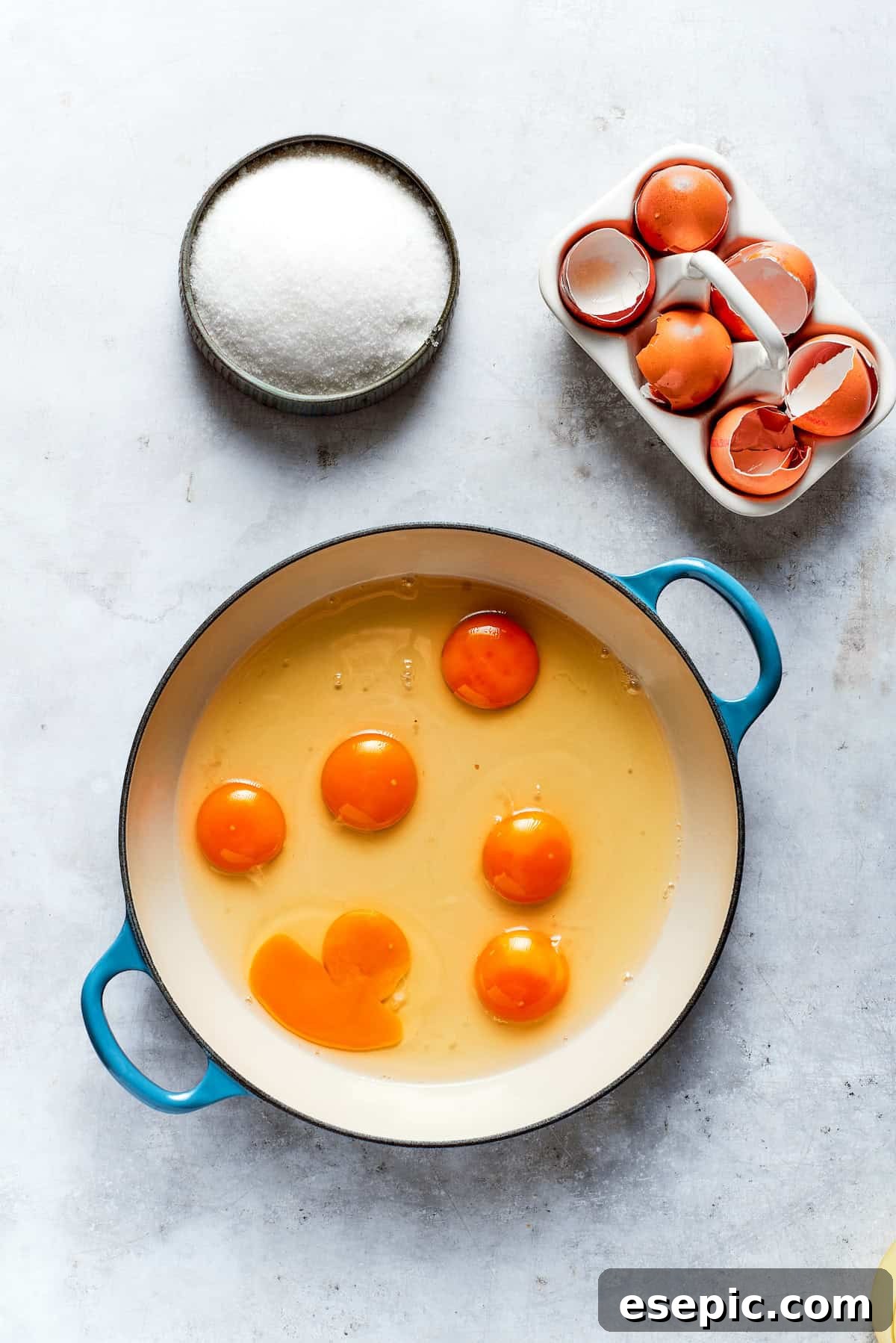 Large eggs being added to a pot, preparing for the lemon curd mixture.