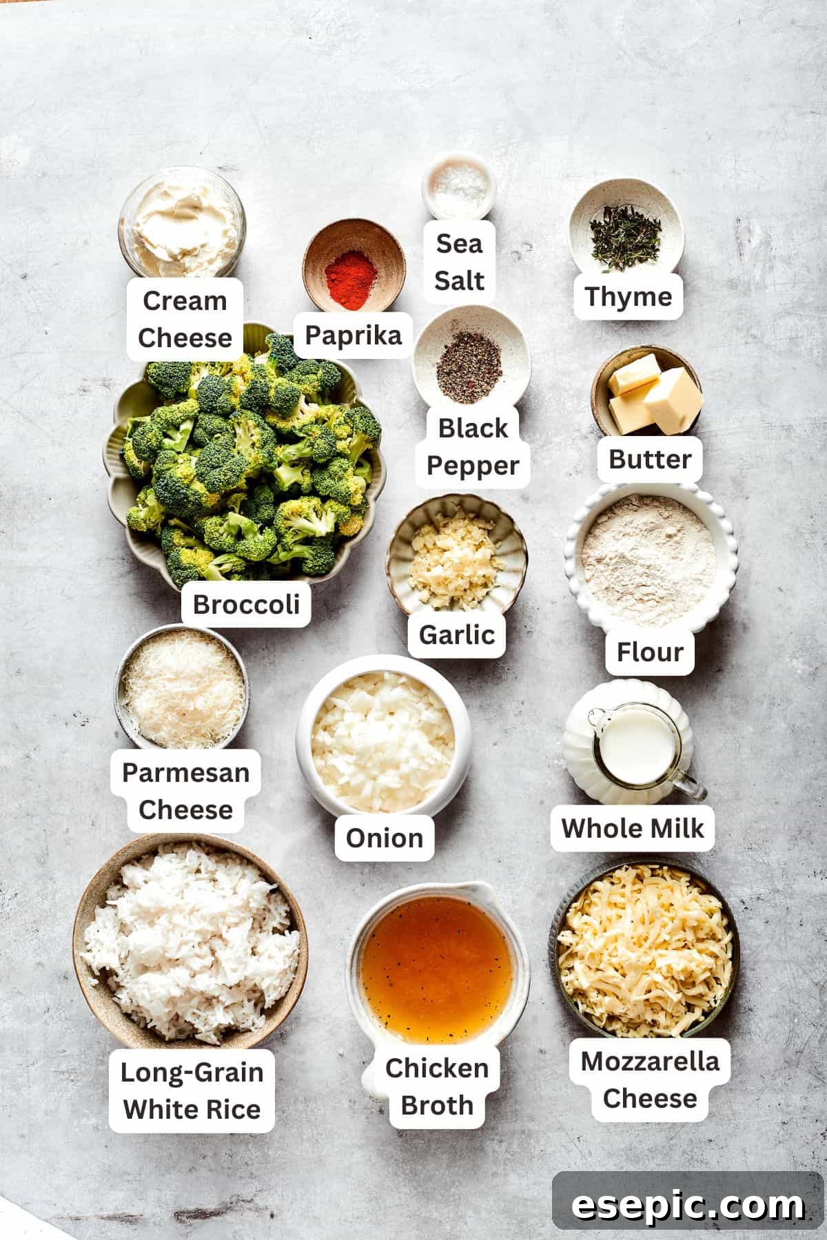 Labeled ingredients for broccoli & rice casserole neatly arranged: fresh broccoli florets, white rice, seasonings like paprika, salt, pepper, garlic, thyme, butter, diced onion, and a selection of Parmesan, cheddar, and mozzarella cheeses, along with flour for the sauce.