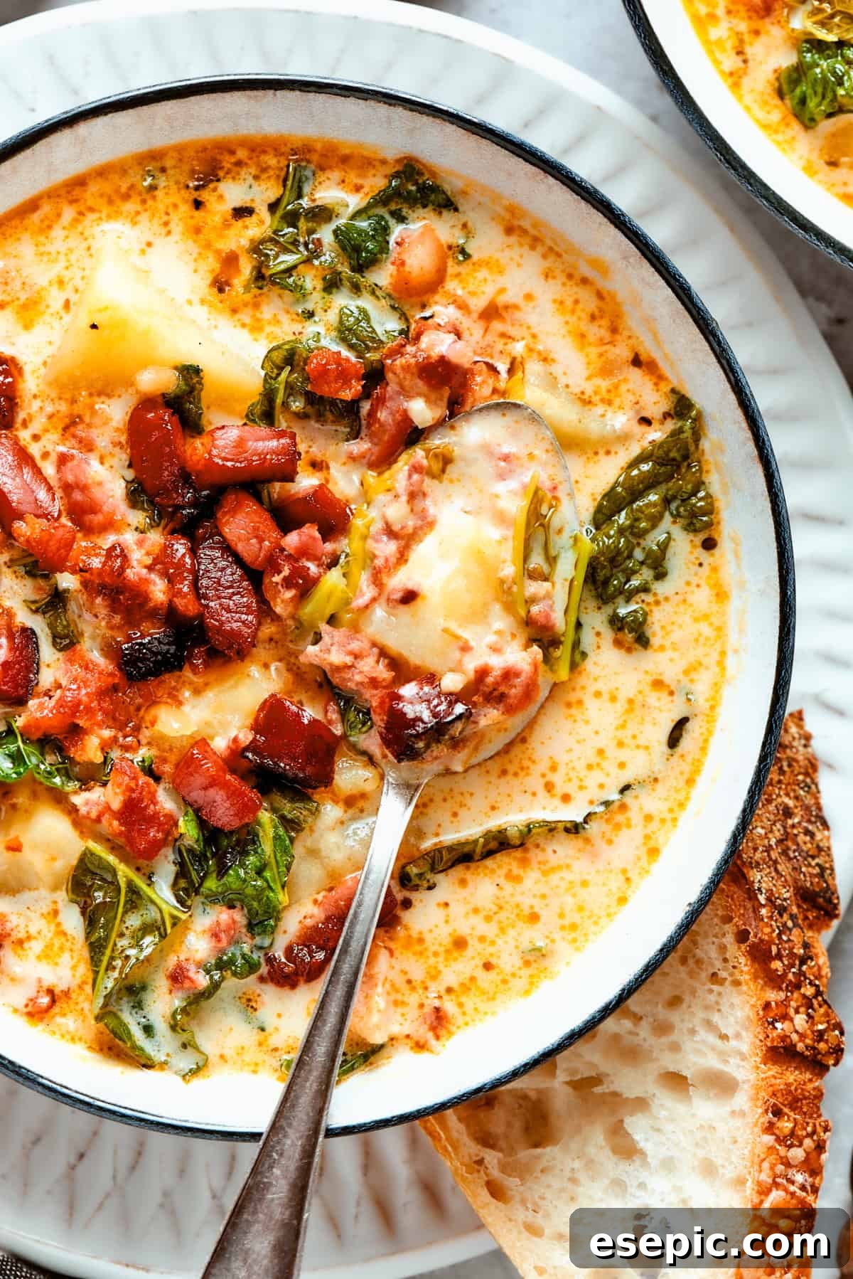 Close-up shot of Zuppa Toscana served in a bowl with a spoon placed inside it, highlighting its rich texture.