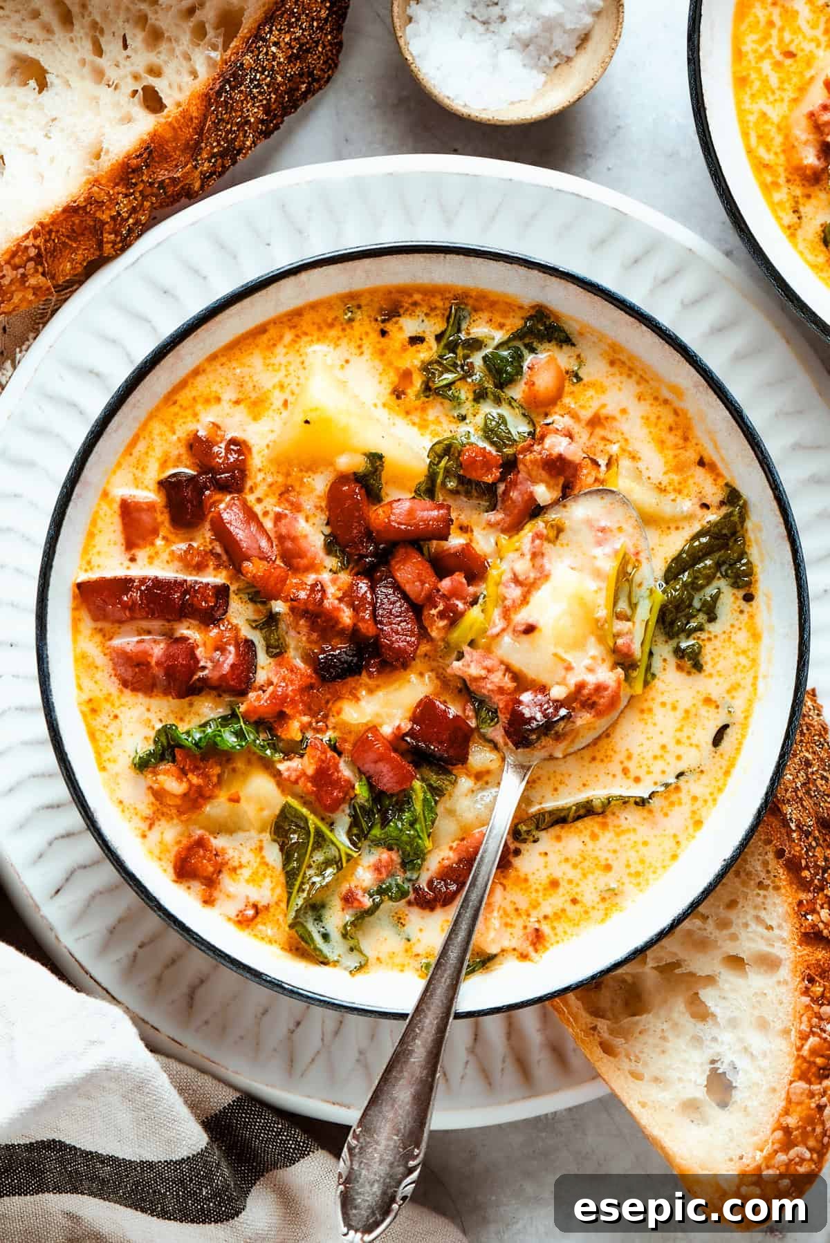 A bowl of Zuppa Toscana served in a bowl and garnished with crumbled bacon, ready to be enjoyed.
