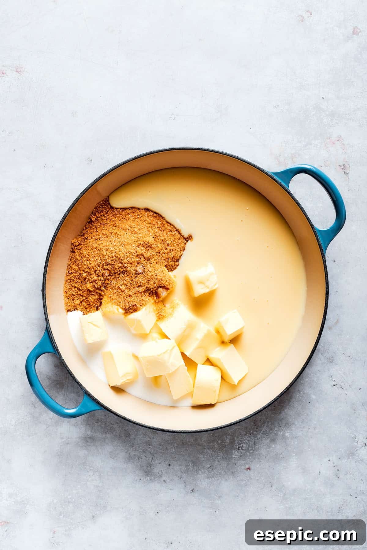 Millionaire Bars are decadent layers of homemade buttery shortbread, creamy caramel, and thick chocolate ganache. A saucepan filled with condensed milk, butter, brown sugar, and heavy cream, ready to be cooked into caramel.