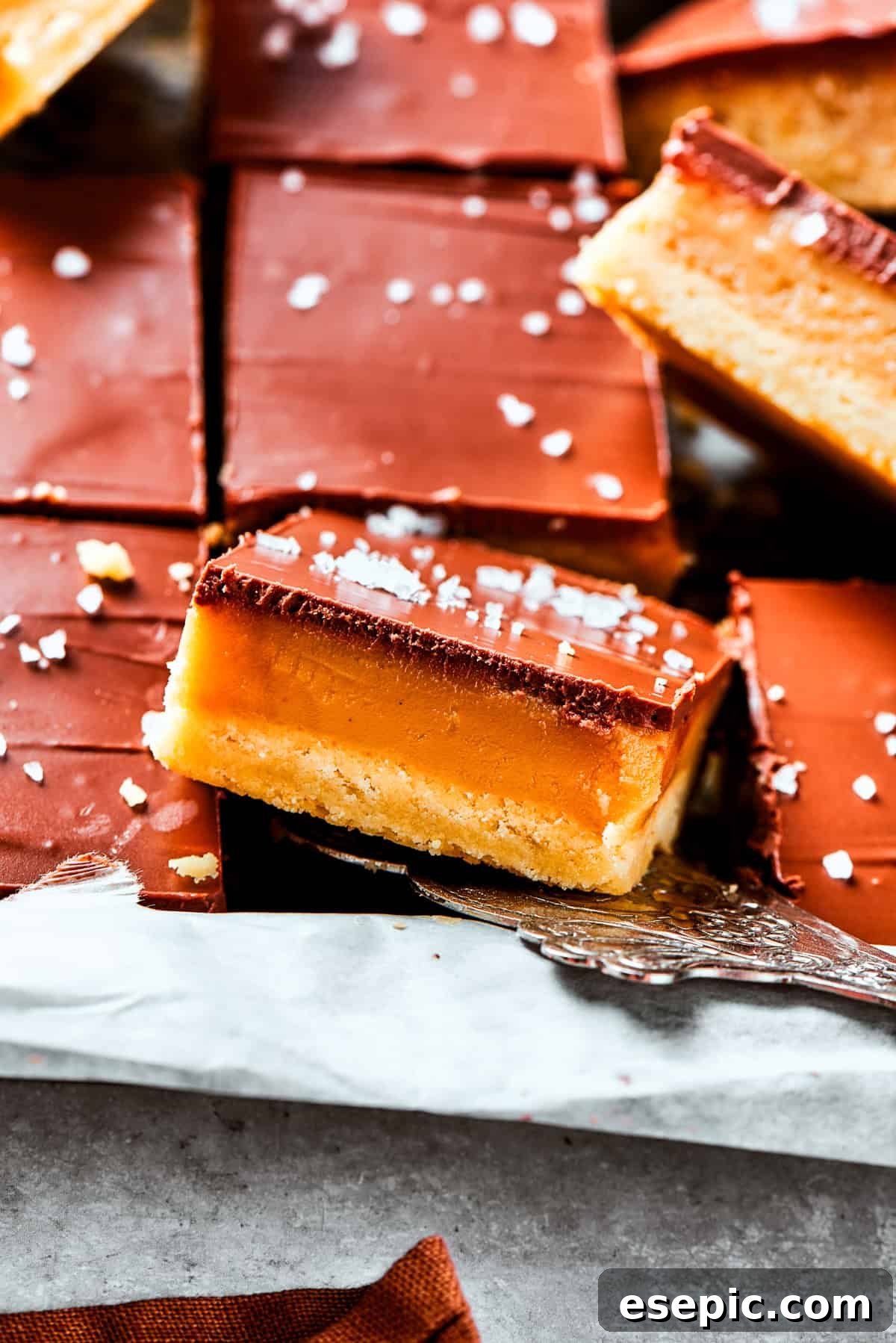 Decadent Caramel Chocolate Squares 2 A side view of a generous pile of perfectly layered Millionaire Bars, ready to be enjoyed.