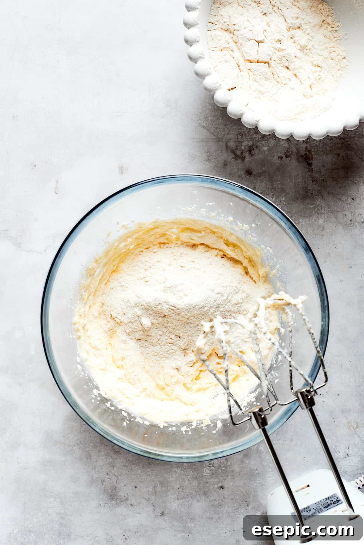 Millionaire Bars are decadent layers of homemade buttery shortbread, creamy caramel, and thick chocolate ganache. Butter and sugar are being creamed together in a mixing bowl, preparing the shortbread dough.