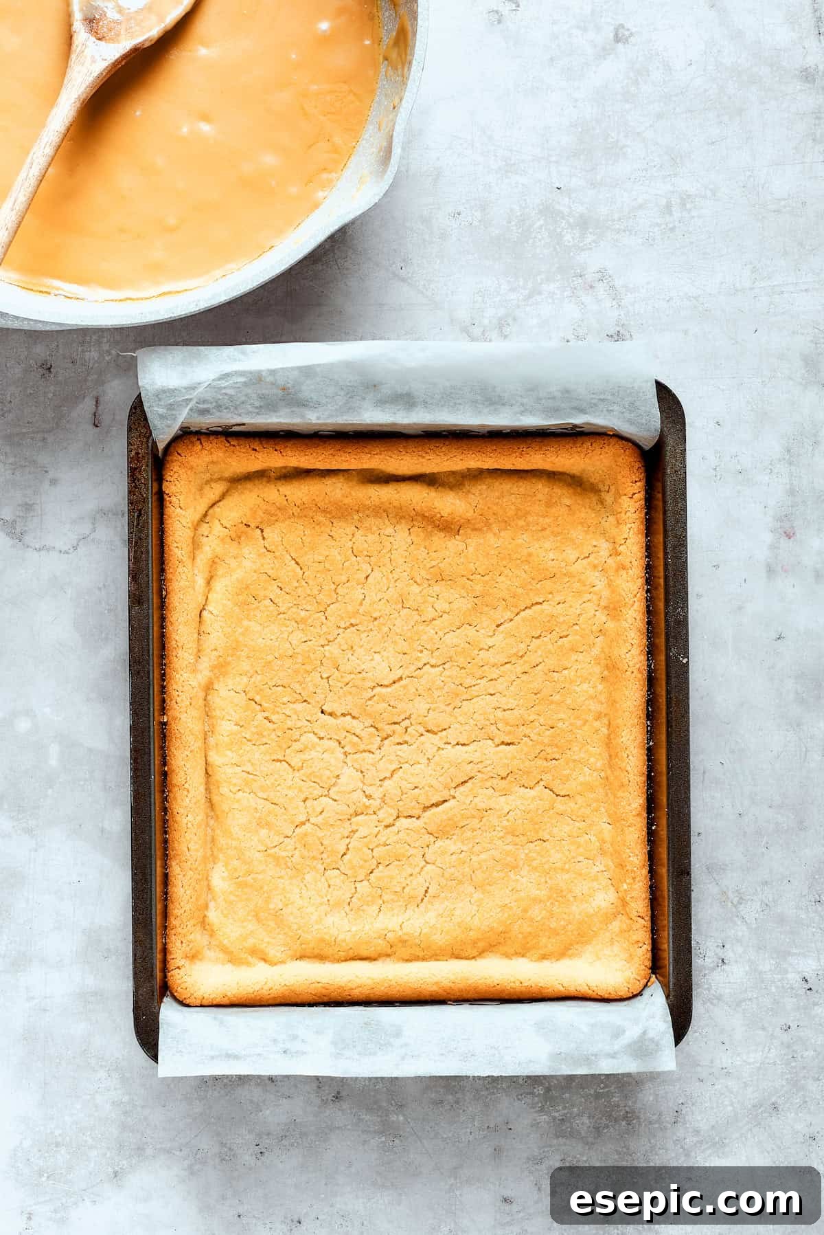Millionaire Bars are decadent layers of homemade buttery shortbread, creamy caramel, and thick chocolate ganache. A golden-brown baked shortbread crust cooling in a baking pan.